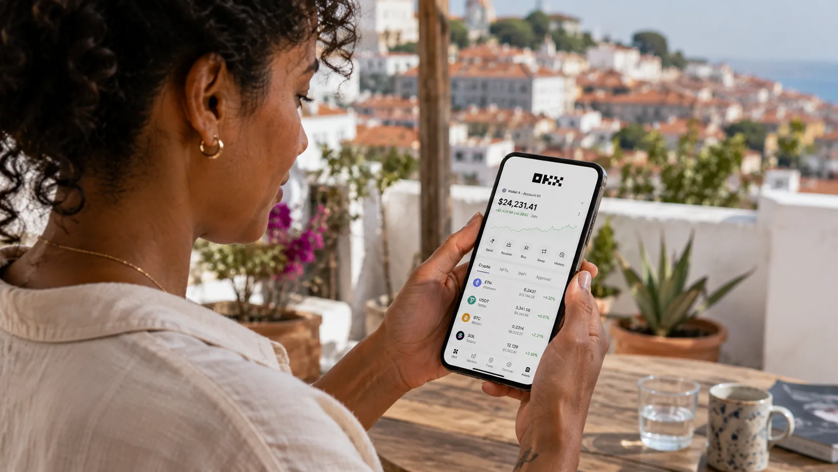 Femme consultant le portefeuille OKX sur son smartphone depuis une terrasse